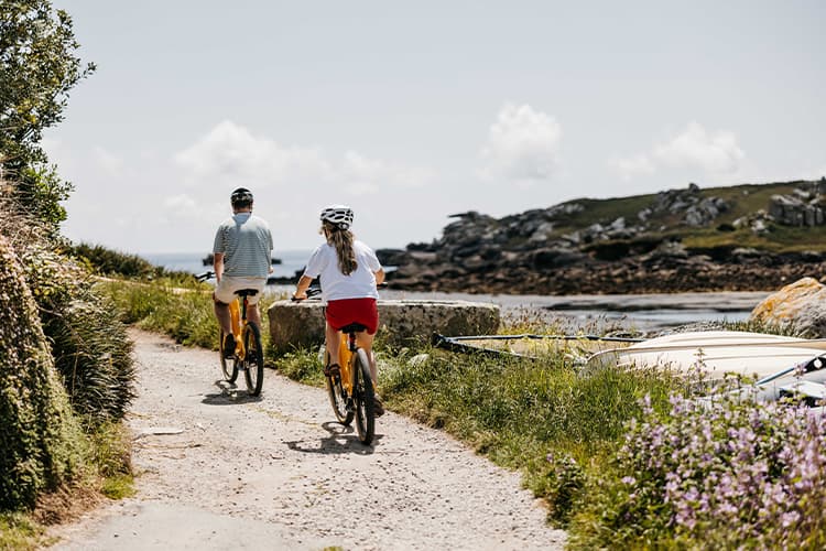 couple cycling through old town, St Mary's - Isles of Scilly