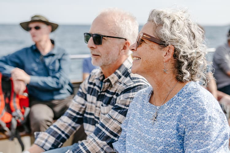 Couple sitting on a St Mary's Boatmen Association tripper boat- Isles of Scilly