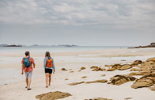 Couple walking along the beach at Pentle Bay, Tresco - Isles of Scilly