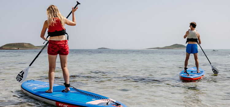 St Martin's Watersports - couple paddle boarding - Par Beach, Higher Town, St martin's